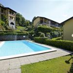 Pool mit umliegenden Gebäuden und Grünflächen
