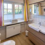 Badezimmer mit Fenster, Waschbecken und Toilette. Badezimmer mit Fenster, Waschbecken und Toilette.