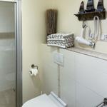 Bad mit Toilette, Dusche und Handtuchhalter mit Segelboot-Dekoration.