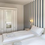 Bedroom with bed, wardrobe, and striped wall