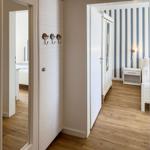Hallway with view into bedroom and wardrobe with striped wall