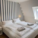 Room with two beds, striped wall, and skylight.