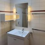 Bathroom with sink, mirror, and shower area.