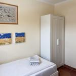 Schlafzimmer mit Bett, Kleiderschrank und Wandbildern.