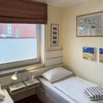 Zimmer mit zwei Betten, Fenster mit Jalousie und Wandbildern