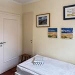 Schlafzimmer mit Bett, Tür und Wandbildern an der Wand.