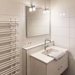 Badezimmer mit Waschbecken, Spiegel und Heizkörper