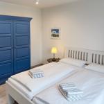 Schlafzimmer mit Doppelbett, blauem Schrank und Nachttisch mit Lampe.