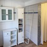 Badezimmer mit weißen Schränken, Duschvorhang und Handtuchhalter.