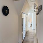 Flur mit Wanduhr, Garderobe und Blick in Schlafzimmer