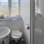 Bathroom with shower, toilet, and sink. Window with view.