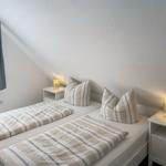 Room with double bed, two nightstands and lamp. Window with curtains.