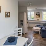 Living and dining area with sofa, table, and wall decor.