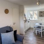 Living and dining area with kitchen, sofa, and table with chairs.