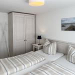 Zimmer mit zwei Betten, Kleiderschrank und Wandbild