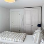 Schlafzimmer mit Bett, KleiderSchrank und Tür.