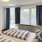 Bedroom with double bed, window, and curtains.