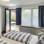 Room with bed, window, and door to garden. Curtain and radiator visible.