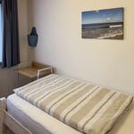 Bedroom with bed, desk, and wall picture