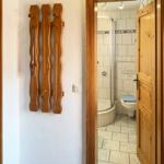 Bathroom with shower and toilet, wooden decor on the wall