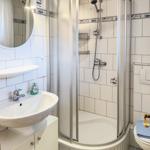 Bathroom with shower, sink and toilet. Tiles with fish motif.