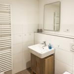 Badezimmer mit Waschbecken, Spiegel und Heizkörper