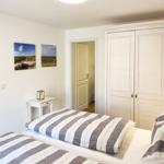 Schlafzimmer mit Doppelbett, Kleiderschrank und Wandbildern