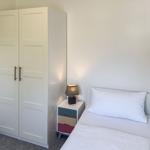 Ein Schlafzimmer mit einem Bett, einem Schrank und einem Nachttisch mit Lampe.