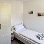 Ein Schlafzimmer mit einem Bett, einem Kleiderschrank und zwei Bildern an der Wand.
