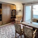 A room with dining area, bookcase, and seating with sea view.