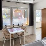A room with a table, two chairs, and a window with a view outside.