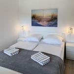 Bedroom with bed, two nightstands, and wall art. Towels are on the bed.