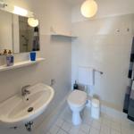 Bathroom with sink, toilet, and shower with curtain.