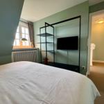 Schlafzimmer mit Bett, Fernseher und Fenster