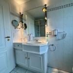 Badezimmer mit Waschbecken, Spiegel und Dusche