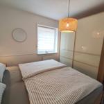 Schlafzimmer mit Bett, Kleiderschrank und Fenster.