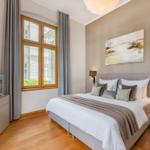 Schlafzimmer mit Bett, Fenster und TV. Holzboden und Wandbild.