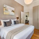 Schlafzimmer mit Bett, Kleiderschrank und Wandbild.