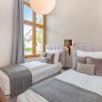 Zwei Betten mit Kissen und Decken. Fenster mit Blick nach draußen.