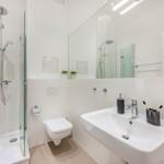 Badezimmer mit Dusche, Waschbecken und Toilette.
