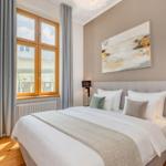 Schlafzimmer mit Bett, Fenster und Wandbild. Holzboden und moderne Beleuchtung.