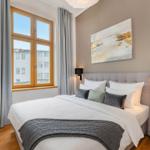 Schlafzimmer mit großem Bett, Fenster und Wandbild.
