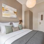 Schlafzimmer mit Bett, Wandbild, Kleiderschrank und Tür.