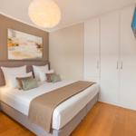 Schlafzimmer mit Doppelbett, Wand-TV und Kleiderschrank.