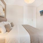 Schlafzimmer mit Bett, Kleiderschrank und Wandbildern.
