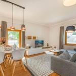 Wohn- und Essbereich mit Sofa, TV und Esstisch mit Stühlen.