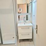 Badezimmer mit Dusche, Waschbecken und Spiegelschrank.