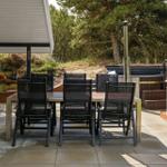 Terrasse mit Tisch, Stühlen und Whirlpool im Grünen