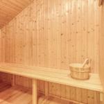 Sauna mit Holzwand, Bank und Eimer