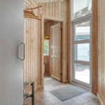 Eingangsbereich mit Holzwand, Tür und Fenster. Fliesenboden und Teppich.